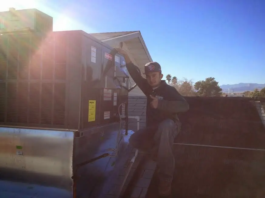 HVAC technician performing HVAC Inspection on a rooftop unit in Lafayette
